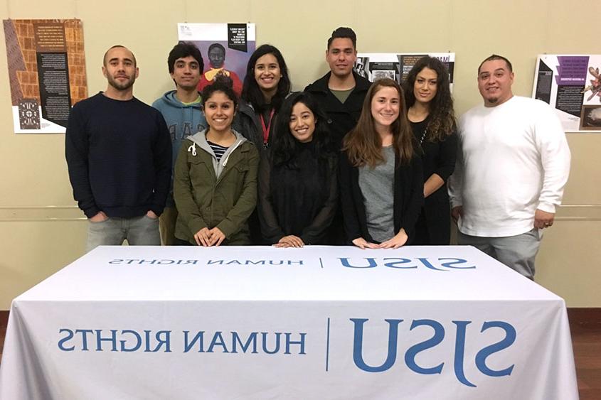 Director W. Armaline and student team behind a booth.